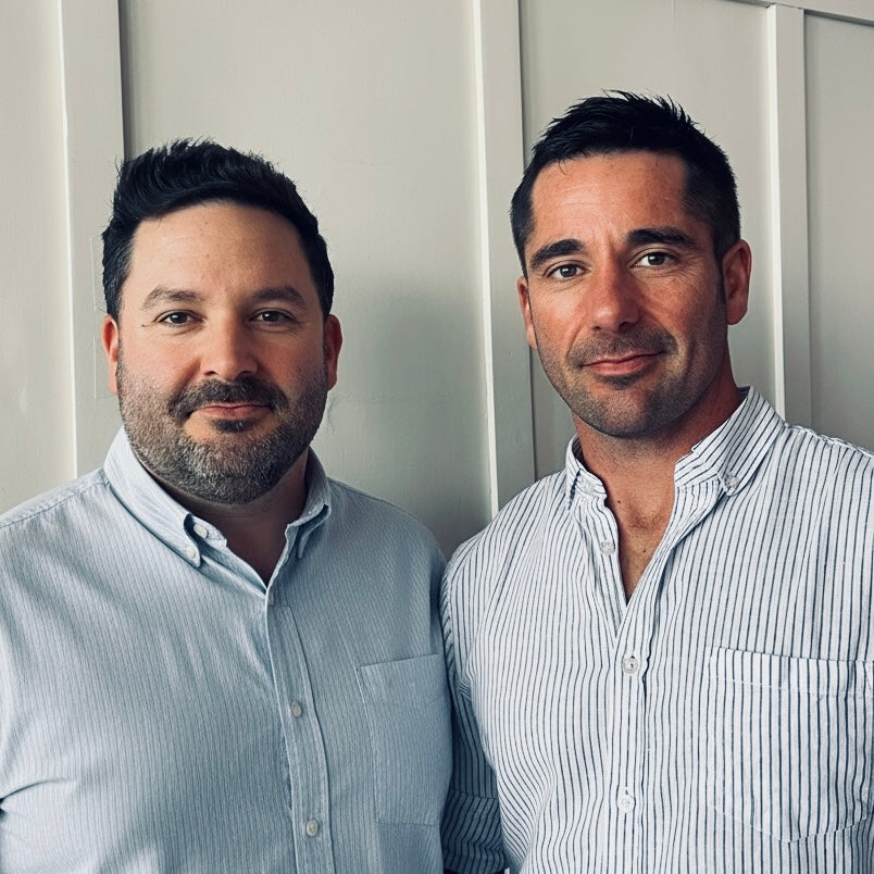 Two men standing side by side against a plain background